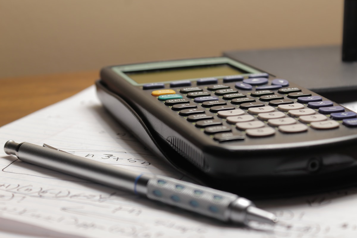 Calculator and pen used to compare textbook costs