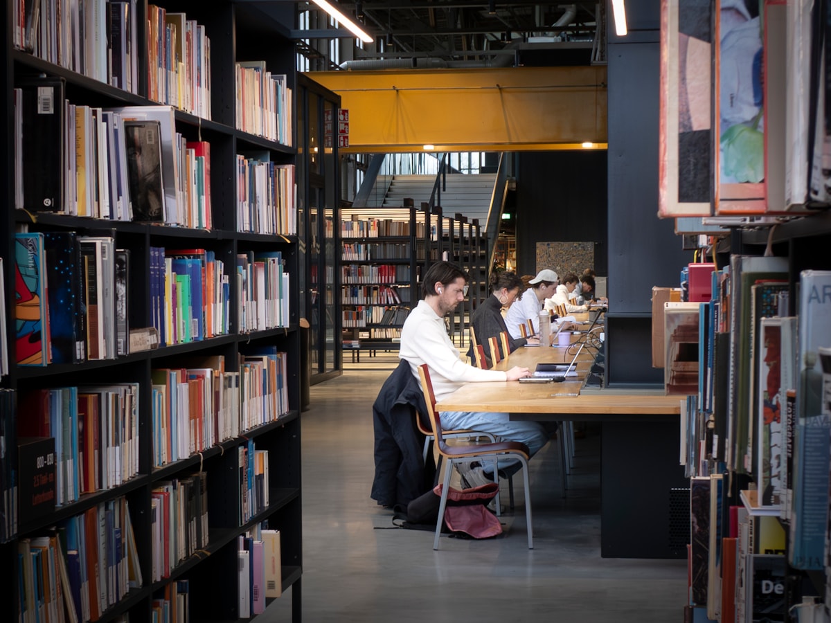 Students studying at long tables in a university library
